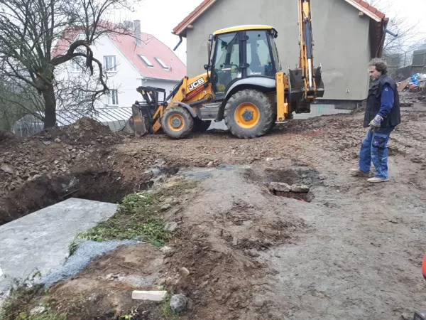 Zemní práce pří terénních úpravách kolem RD, včetně hloubení základu pro betonovou jímku.